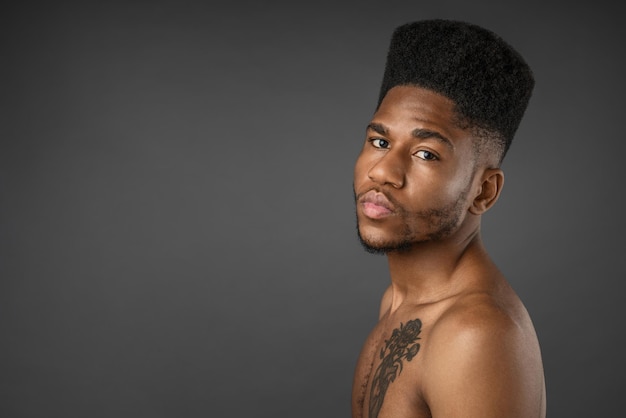 Handsome young man standing isolated over grey background