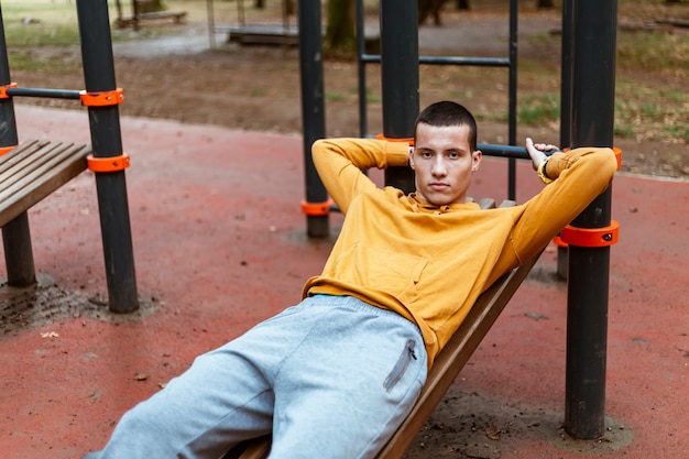 写真 秋の公園でストレッチハンサムな若い男