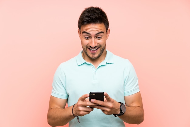 Handsome young man surprised and sending a message