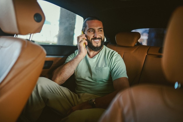 A handsome young man talking on the phone in a car