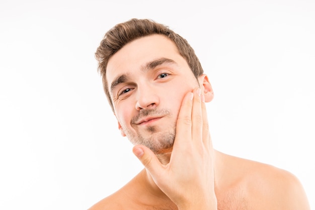 Handsome young man touching his face after shave