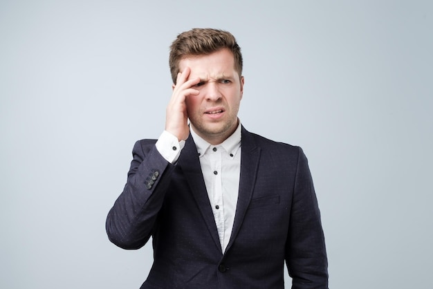 Handsome young man touching his head with hand feeling strong headache