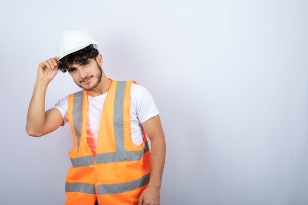 Handsome young man in uniform standing over white wall. High quality photo