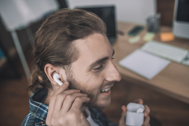 A handsome young man using wireless earphones