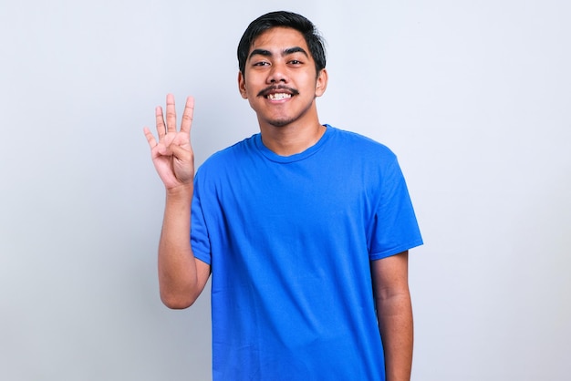 Handsome young man wearing casual t-shirt showing and pointing up with fingers number four while smiling confident and happy over white background