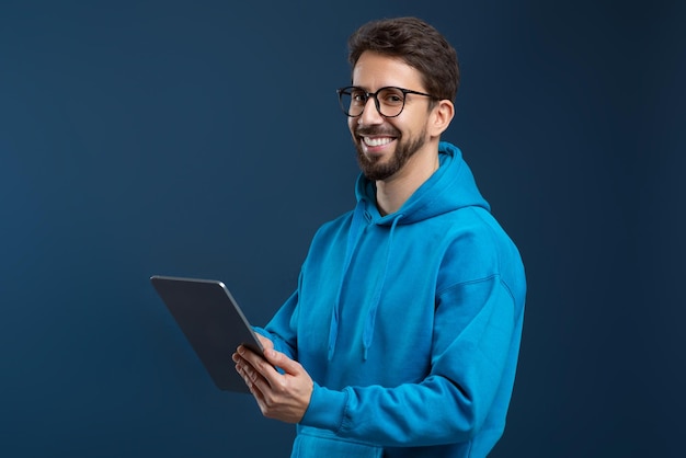 Photo handsome young man wearing glasses and blue hoodie using digital tablet