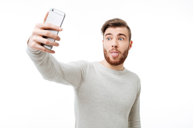 Handsome young man in a white sweater using the phone