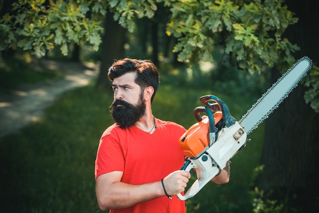 Handsome young man with axe near forest stylish young man posing like lumberjack a handsome young ma...