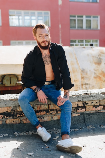 Photo a handsome young man with a beard in a grunge-style interior