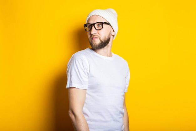 Handsome young man with beard in hat and glasses 