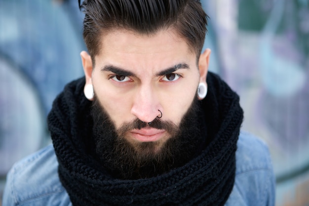 Bel giovanotto con barba e piercing