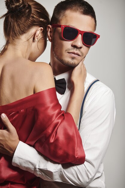 Handsome young man with fashionable sunglasses posing with girl