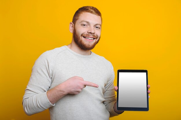 Handsome young man with ginger beard smiling and looking at camera