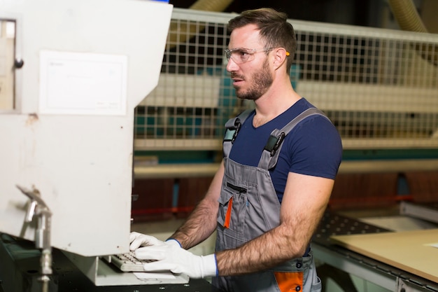 Handsome young man working in the furniture factory