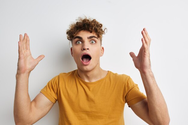 Handsome young man in yellow tshirts gesture hands emotions isolated background