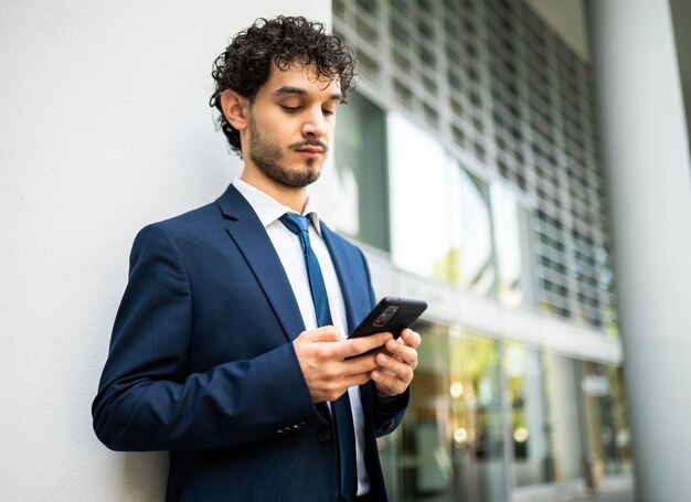 Handsome young manager using a smartphone outdoor