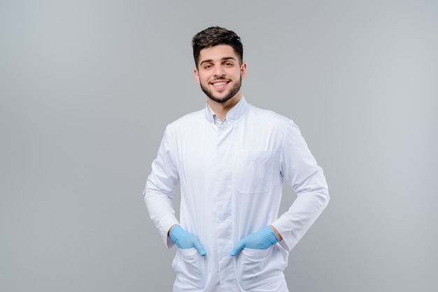 Foto giovane medico bello in guanti isolati sopra grey