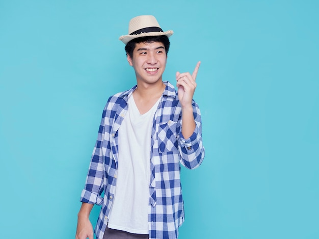 Handsome young men pointing on blue wall