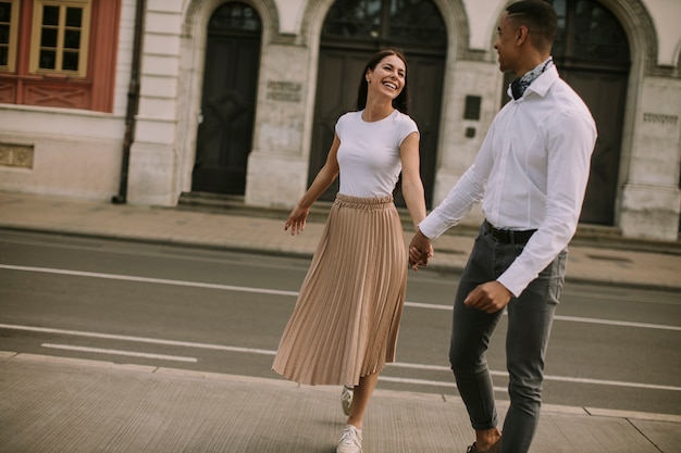 Photo handsome young multiethnic couple walking on the street