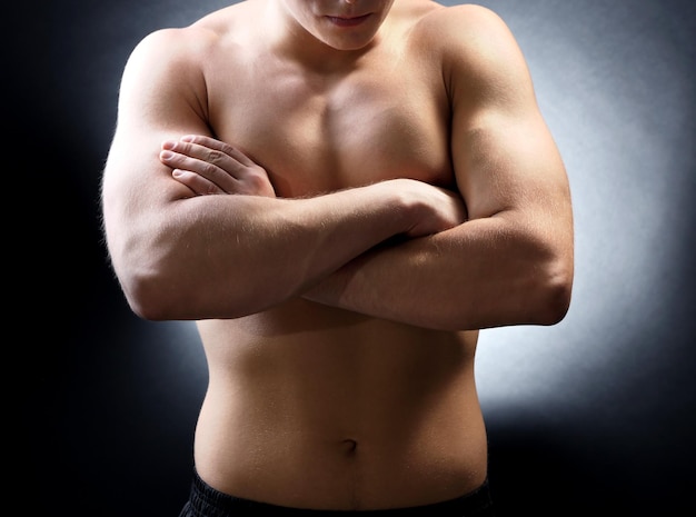 Handsome young muscular sportsman on dark background