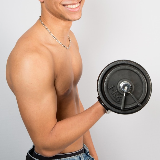 Handsome young muscular sportsman execute exercise with dumbbells