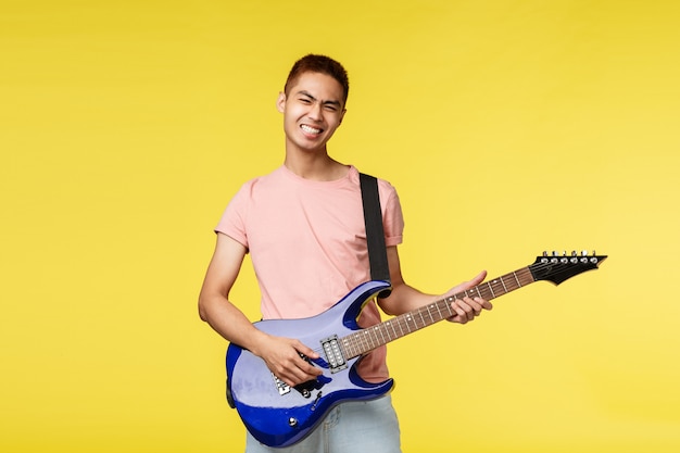 Handsome young musician playing the guitar and singing