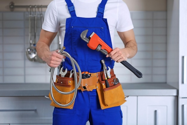 handsome young plumber in kitchen closeup