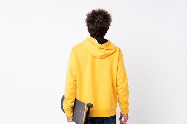 Handsome young skater man over white wall