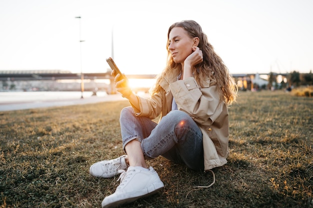 Handsome young smiling woman with mobile phone in the street