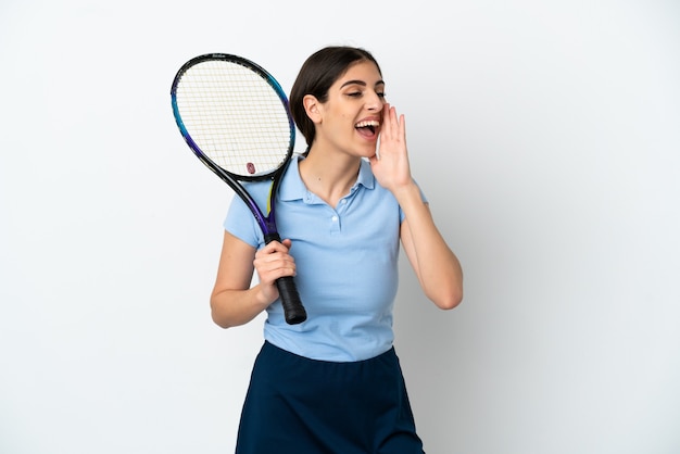 잘 생긴 젊은 테니스 선수 백인 여자는 입 벌리고 측면으로 외치는 흰색 배경에 고립