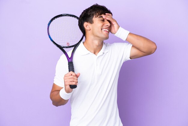 Handsome young tennis player man isolated on ocher background smiling a lot