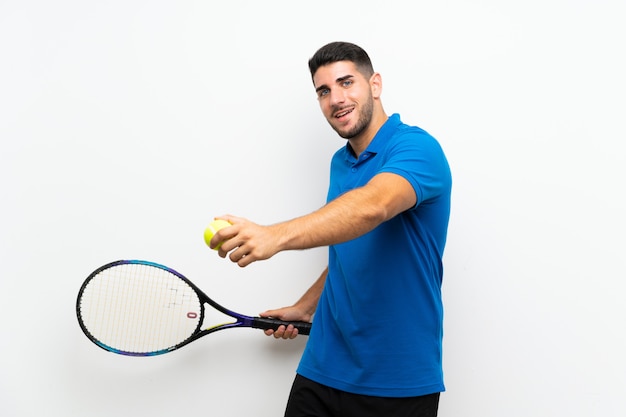 Handsome young tennis player man over isolated white wall 