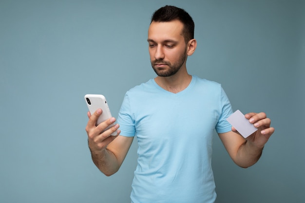 Bel giovane uomo con la barba lunga brunet con la barba che indossa la maglietta blu tutti i giorni isolato