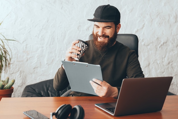 handsome young worker man in office drinking coffee and reading documents