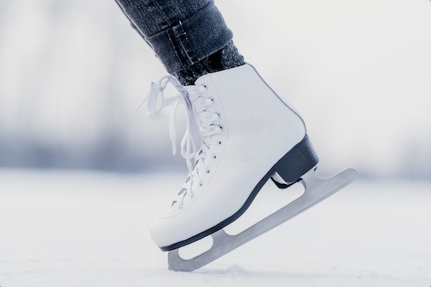 Handstand on the tips of ice skates on a frozen winter lake