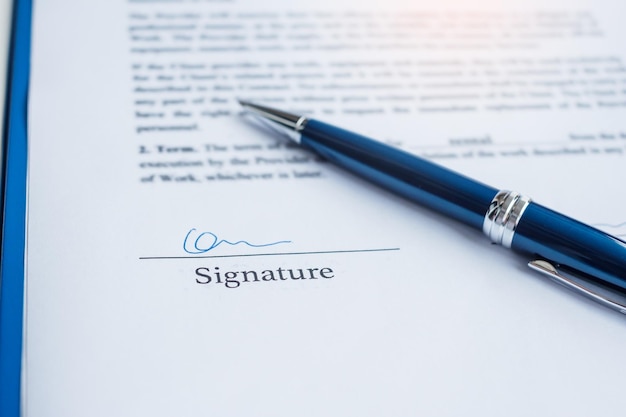 Handtekening met pen op contractdocumenten contractovereenkomst keurt wet goed en dealconcepten