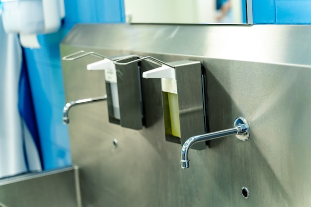 Handwasruimte in het ziekenhuis. Steriele stalen wastafel in moderne operatiekamer.