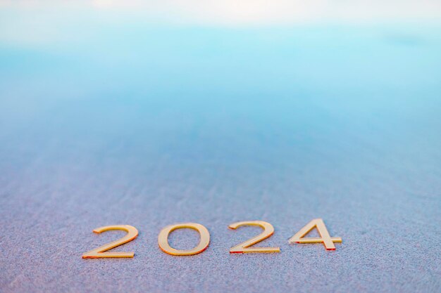 handwritten inscription 2024 on the sand by the sea happy new year