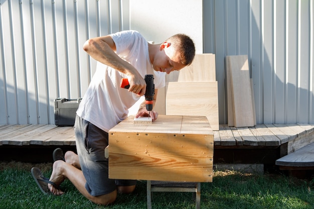 Handyman in blue uniform works with electricity automatic
screwdriver. house renovation conception.