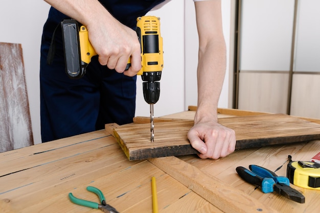 Handyman in blue uniform works with electricity automatic
screwdriver house renovation conception