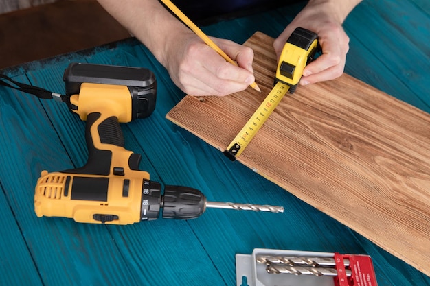 Handyman in blue uniform works with electricity automatic screwdriver House renovation conception