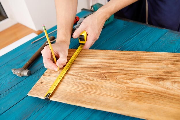 Handyman in blue uniform works with electricity automatic screwdriver