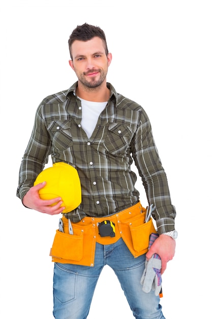 Handyman die hulpmiddelriem draagt ​​terwijl het houden van helm en handschoenen