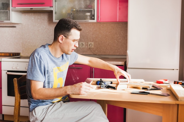 Uomo del tuttofare che fa il lavoro di carpenteria nella cucina