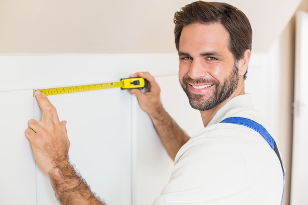 Handyman measuring a wardrobe