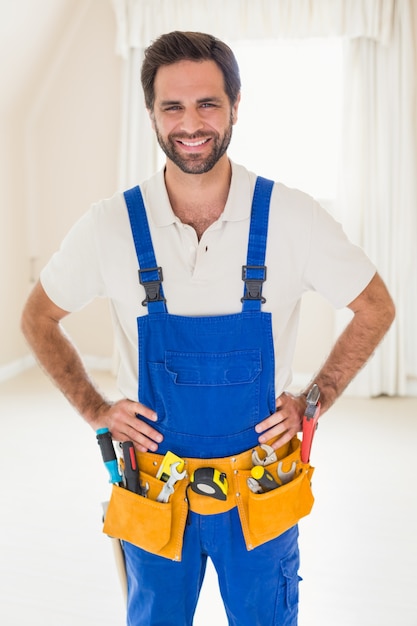 Handyman smiling at camera in tool belt