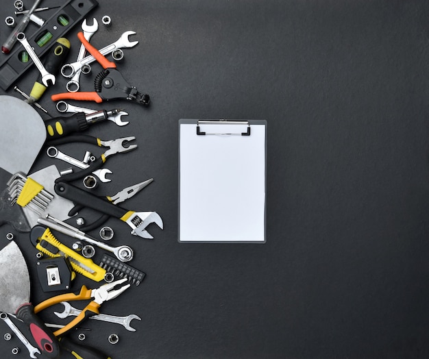 Handyman tool kit on black wooden table. Many wrenches and screwdrivers, pilers and other tools for any types of repair or construction works