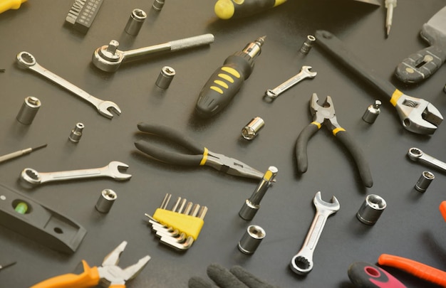 Handyman tool kit on black wooden table many wrenches and screwdrivers pilers and other tools for