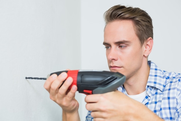 Handyman using a cordless drill to the wall