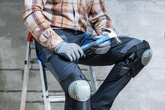 Handyman with construction tools against grey background